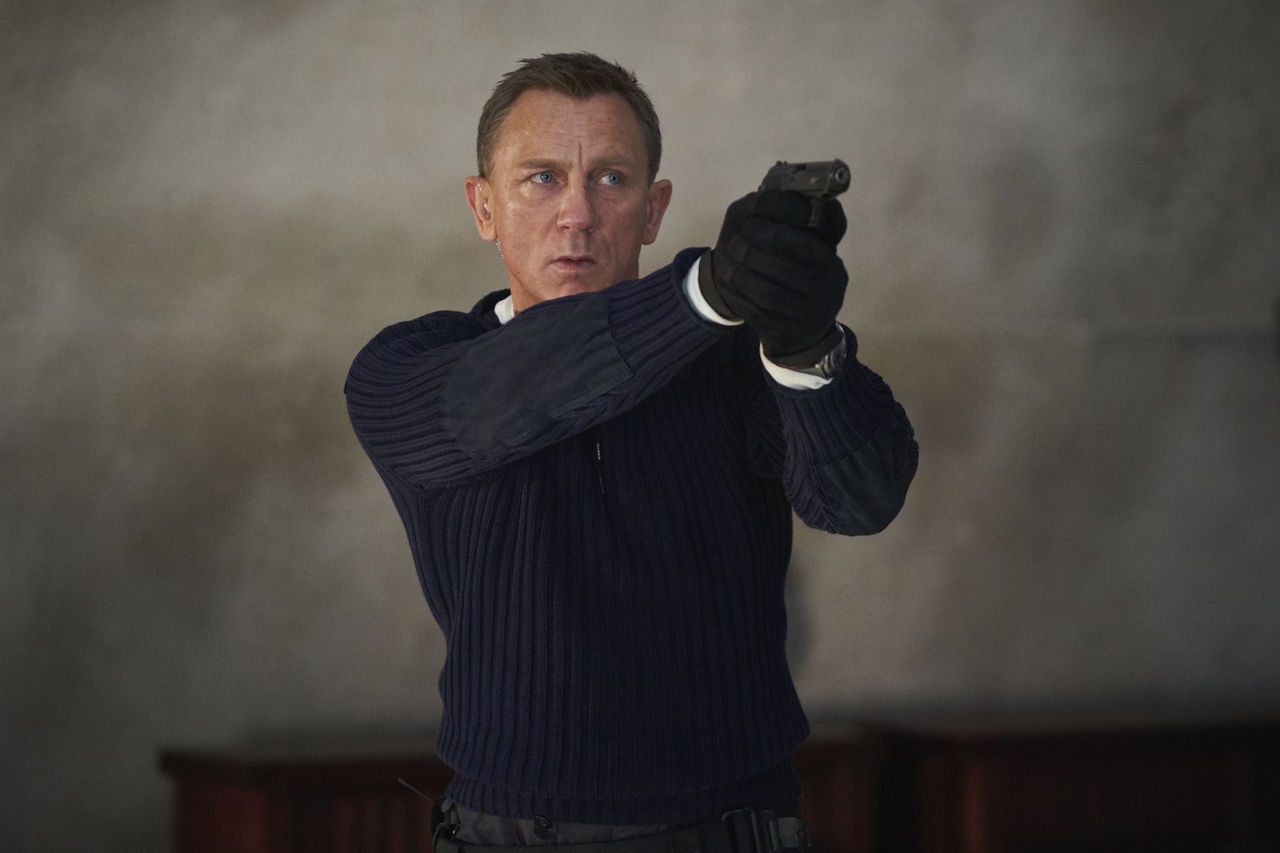 Daniel Craig as James Bond with a gun in No Time to Die