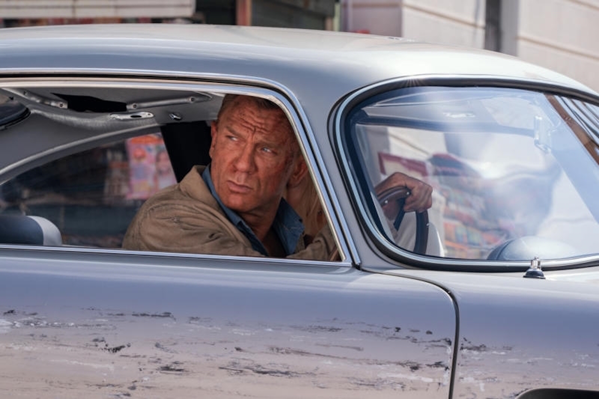 Daniel Craig as James Bond driving in No Time to Die
