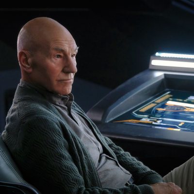 Patrick Stewart as Jean-Luc Picard, sitting in a chair on the bridge of a ship