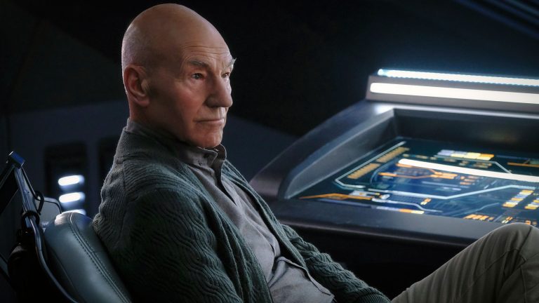 Patrick Stewart as Jean-Luc Picard, sitting in a chair on the bridge of a ship