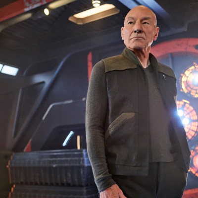 Patrick Stewart as Jean-Luc Picard stands on the bridge of a ship