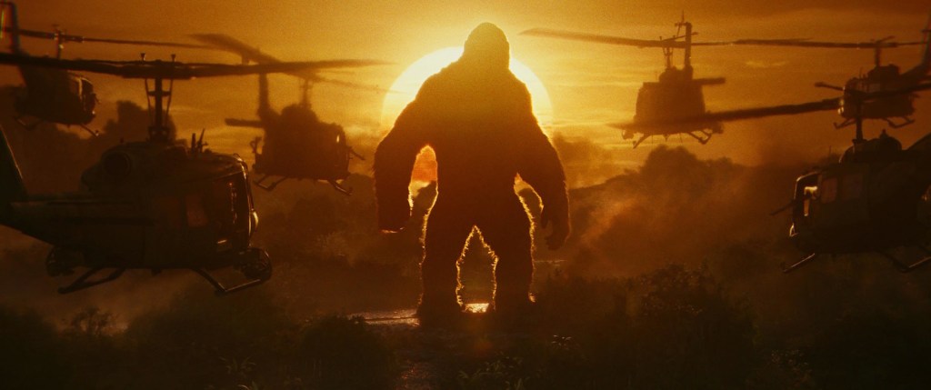 Kong standing before helicopters in Kong Skull Island