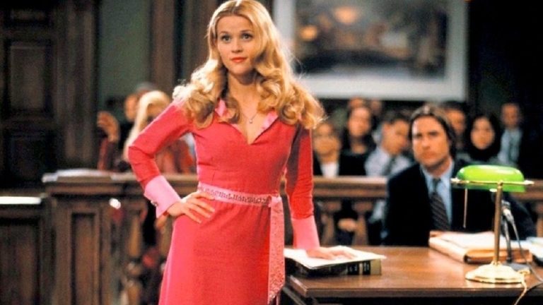 Reese Witherspoon as Elle Woods, dressed in pink, standing in a courtroom in Legally Blonde