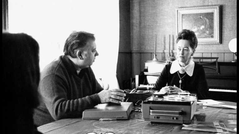 Ed and Lorraine Warren speaking at table with a tape player and record