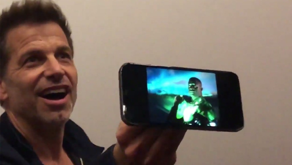 Zack Snyder holding an image of Wayne T. Carr as Green Lantern.