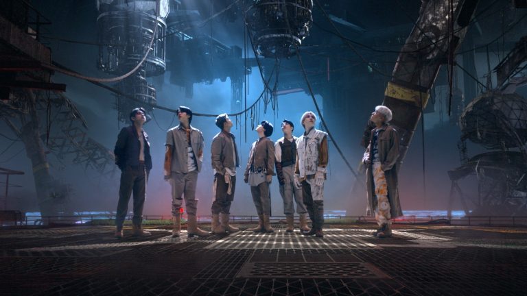 The seven members of BTS against a futuristic planetscape in the "My Universe" music video