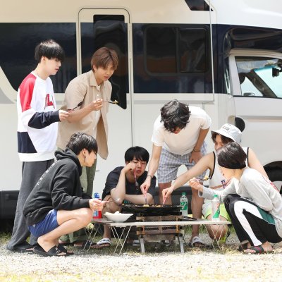 The seven members of BTS eat kimchi fried rice out of a cauldron lid