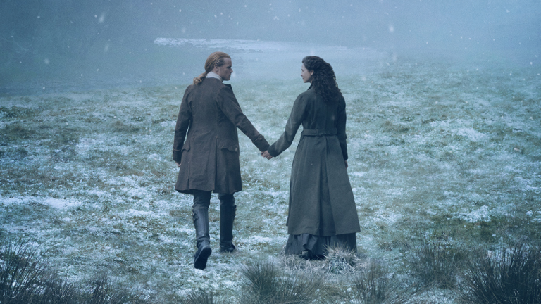Outlander's Jamie and Claire hold hands in the snow