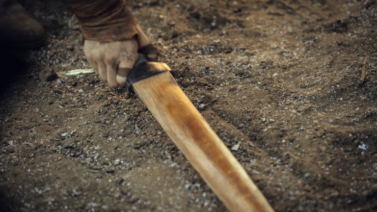 Hand grabbing sword on the ground