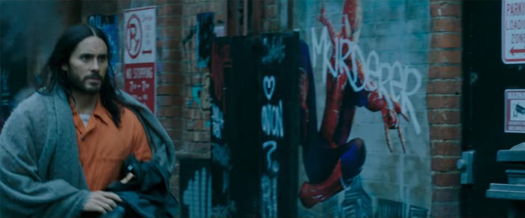 Jared Leto's Morbius walking by a Spider-Man poster.