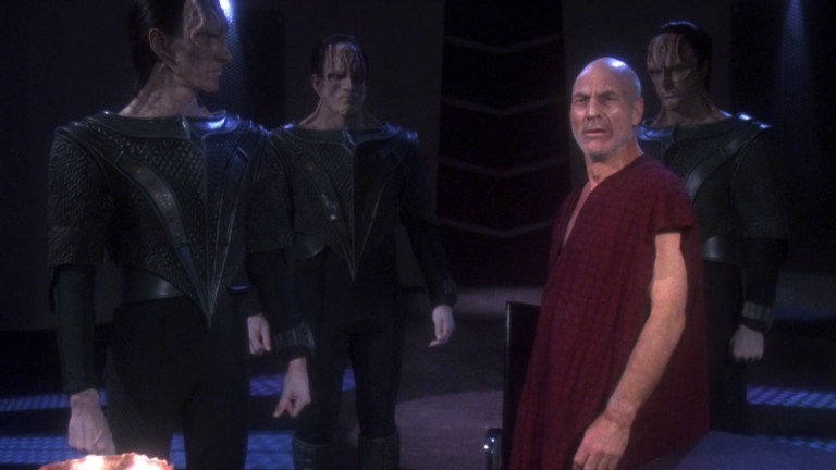 An exhausted Jean-Luc Picard stands amongst his Cardassian torturers in Star Trek episode The Chain of Command