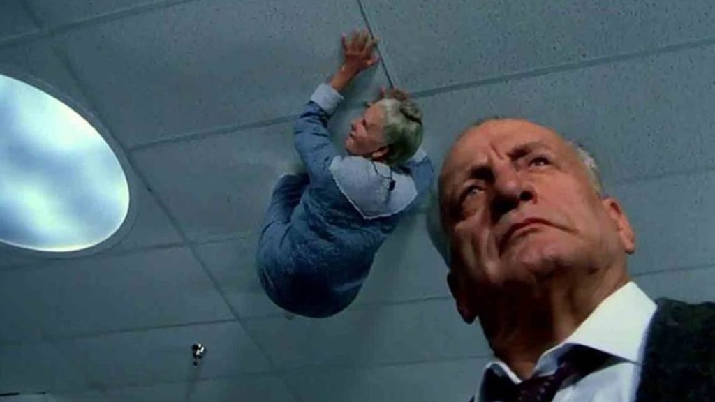Old person crawling and George. Scott in The Exorcist III
