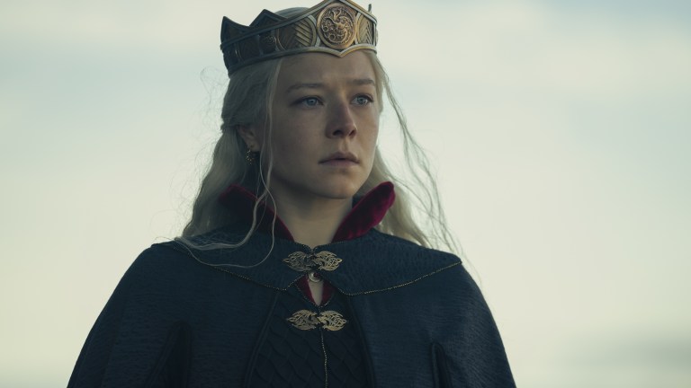 Queen Rhaenrya Targaryen (Emma D'Arcy) stands outside Dragonstone in her golden crown and black cloak