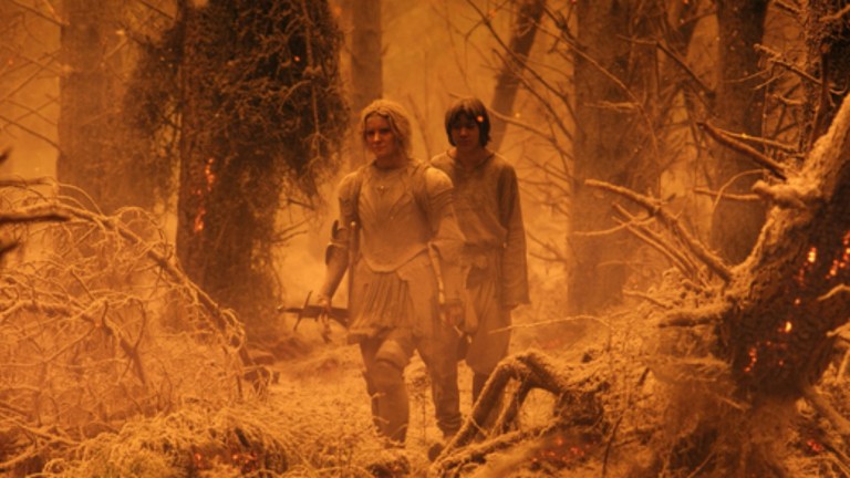 Galadriel (Morfydd Clark) and Theo (Tyroe Morhafadin) walk through the destruction in the Southlands