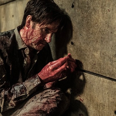 Josh Hamilton as Lance Hornsby examines a bloody coin in The Walking Dead season 11 episode 20.