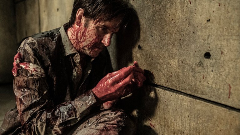 Josh Hamilton as Lance Hornsby examines a bloody coin in The Walking Dead season 11 episode 20.