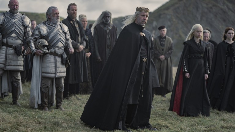 King Viserys I (Paddy Considine), Otto Hightower (Rhys Ifans), Princess Rhaenys Targaryen (Eve Best), Lord Corlys Velaryon (Steve Toussaint), Princess Rhaenrya Targaryen (Milly Alcock), and Lady Alicent Hightower (Emily Carey) gather for a funeral