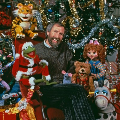 American puppeteer and filmmaker Jim Henson (1936 - 1990) with muppet characters from the ABC TV movie 'The Christmas Toy', directed by Eric Till, 1986. Sitting next to Henson is Muppet character Kermit the Frog in a Santa Claus outfit.