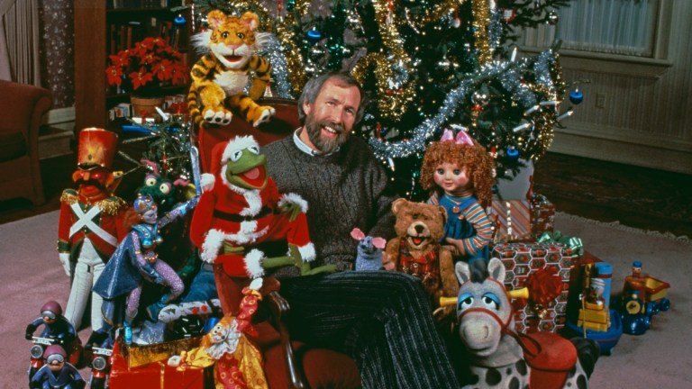 American puppeteer and filmmaker Jim Henson (1936 - 1990) with muppet characters from the ABC TV movie 'The Christmas Toy', directed by Eric Till, 1986. Sitting next to Henson is Muppet character Kermit the Frog in a Santa Claus outfit.