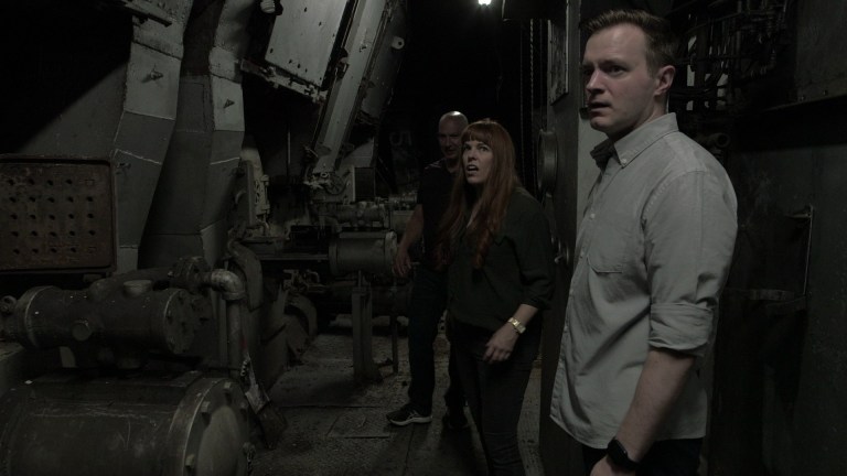 Paranormal investigators Adam Berry and Amy Bruni listening to paranormal investigator Brad Blair describe physically aggressive activity in the coal room of the Museum Ship Valley Camp in Sault Ste. Marie, MI.