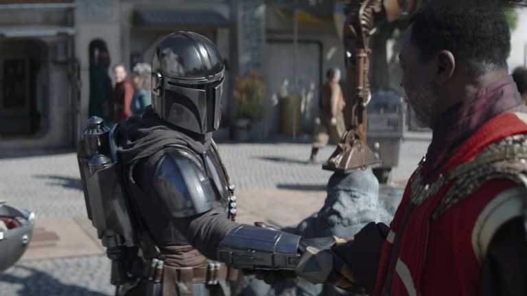 The Mandalorian (Pedro Pascal) shakes hands with Greef Karga (Carl Weathers)