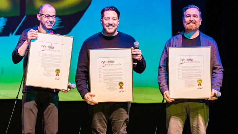 Murr, Sal, and Q of Impractical Jokers onstage at an event commemorating Impractical Jokers Day.