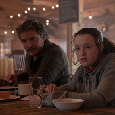 Joel (Pedro Pascal) and Ellie (Bella Ramsey) eat a hot meal in the mess hall of Jackson, Wyoming
