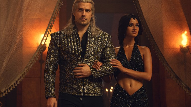 Geralt (Henry Cavill) and Yennefer (Anya Chalotra) enter the Conclave ball at Aretuza