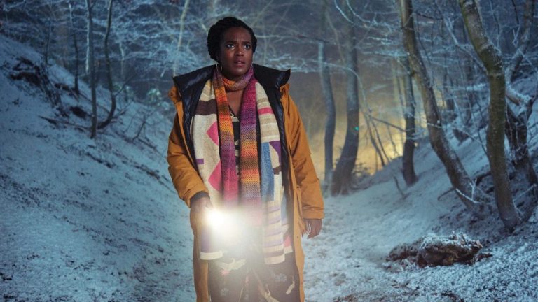 Wunmi Mosaky as Riya in a forest, holding a torch in Passenger ITV
