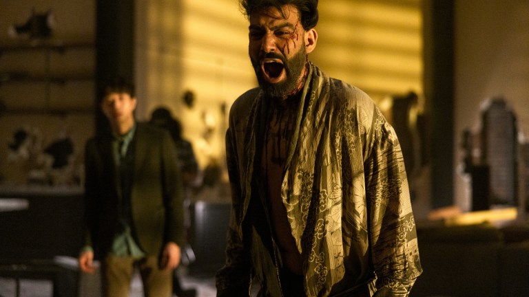 Daniel Jun as Julius stands in the background while Rahul Kohli as Napoleon Usher stands bloody and screaming in Netflix's Fall of the House of Usher