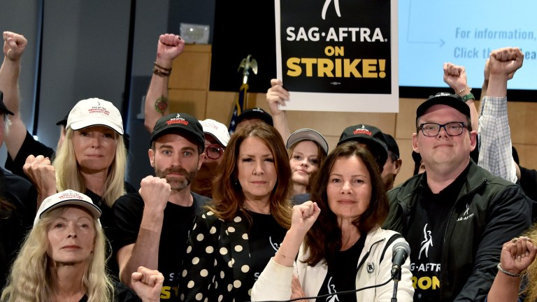 TOPSHOT - US actress Frances Fisher, SAG-AFTRA secretary-treasurer US actress Joely Fisher, SAG-AFTRA President US actress Fran Drescher, and National Executive Director and Chief Negotiator Duncan Crabtree-Ireland, joined by SAG-AFTRA members, pose for a photo during a press conference at the labor union's headquarters in Los Angeles, California, on July 13, 2023. Tens of thousands of Hollywood actors will go on strike at midnight Thursday, effectively bringing the giant movie and television business to a halt as they join writers in the first industry-wide walkout for 63 years. The Screen Actors Guild (SAG-AFTRA) issued a strike order after last-ditch talks with studios on their demands over dwindling pay and the threat posed by artificial intelligence ended without a deal. (Photo by Chris Delmas / AFP) (Photo by CHRIS DELMAS/AFP via Getty Images)