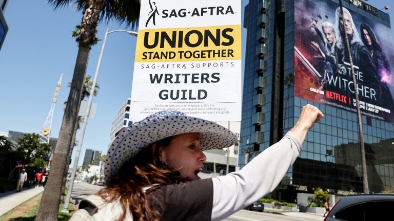 LOS ANGELES, CALIFORNIA - JULY 12: SAG-AFTRA member Christine Robert pickets in solidarity with striking WGA (Writers Guild of America) workers outside Netflix offices on July 12, 2023 in Los Angeles, California. Members of SAG-AFTRA, which represents actors and other media professionals, may go on strike by 11:59 p.m. today which could shut down Hollywood productions completely with the writers in the third month of their strike against Hollywood studios.