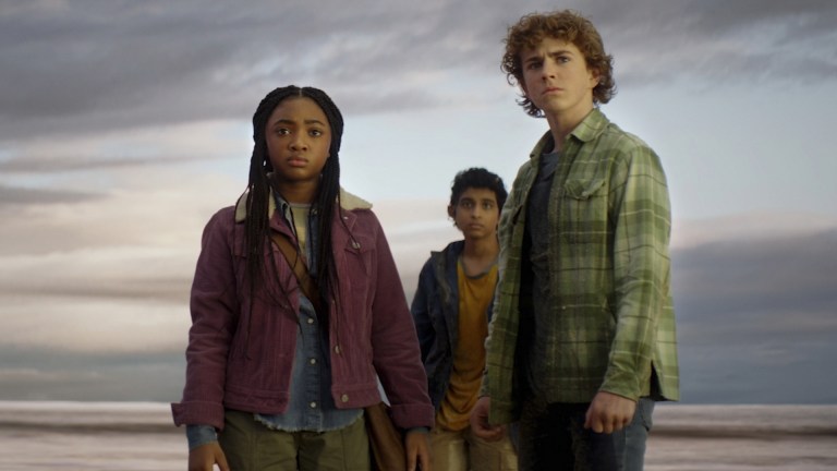 Annabeth Chase (Leah Sava Jeffries), Grover Underwood (Aryan Simhadri), and Percy Jackson (Walker Scobell) stand on a beach in Percy Jackson and the Olympians