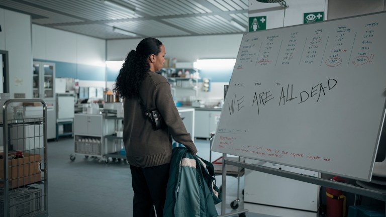 Evangeline Navarro (Kali Reis) looking at a white board that says "We are all dead." in True Detective: Night Country.