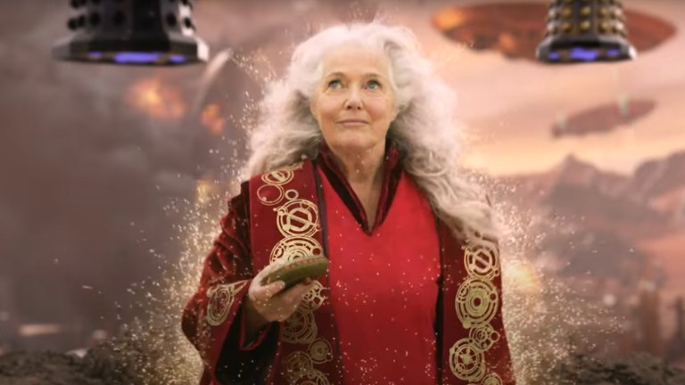 Louise Jameson as the Doctor's companion Leela on the Time War battlefield holding a transporter