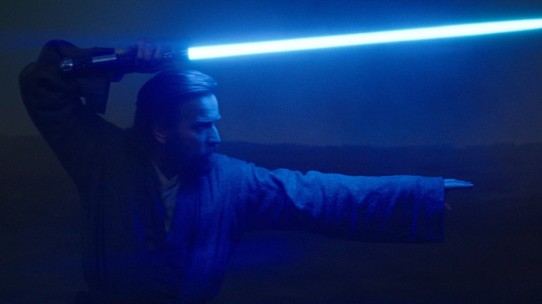 Obi-Wan Kenobi (Ewan McGregor) stands holding his blue lightsaber at the ready