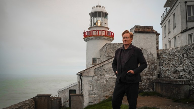 Conan O'Brien stands in front of a lighthouse in Conan O'Brien Must Go