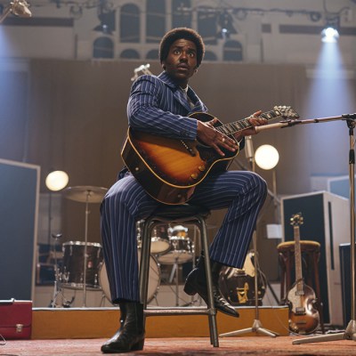 Ncuti Gatwa as The Doctor in 1960s clothing playing a guitar in Doctor Who episode "The Devil's Chord"