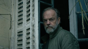 Hugo Weaving standing by a window shutter in Slow Horses season 4