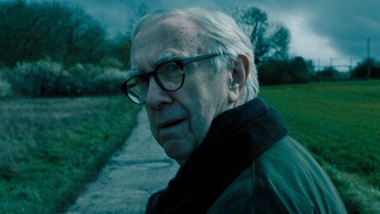 Jonathan Pryce as David Cartwright standing in a country lane in Slow Horses season 4