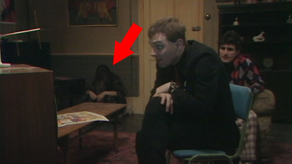 Screengrab of The Young Ones episode "Demolition" with an arrow pointing at the hidden fifth housemate