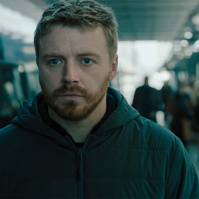 Jack Lowden as River Cartwright walking through a train station in Slow Horses season 4