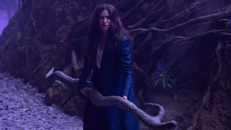 Agatha Harkness (Kathryn Hahn) stands on the Witches' Road holding a broom in Marvel Television's AGATHA ALL ALONG
