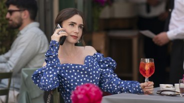 Lily Collins wearing a blue dress and talking on the phone in Emily in Paris season 4