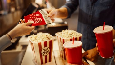 Cinema tickets being handed to customers with popcorn and drinks https://www.gettyimages.co.uk/detail/photo/buying-movie-tickets-royalty-free-image/1488301035?adppopup=true
