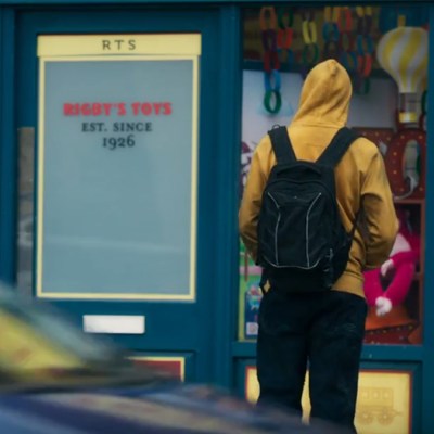 A person wearing a yellow hoodie standing outside of a toy shop - screengrab from The Devil's Hour season 2