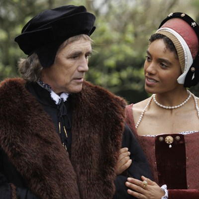 Mark Rylance and Maisie Richardson-Sellers in 16th century costume walking in a garden in Wolf Hall: The Mirror and the Light