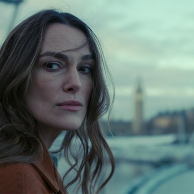 Keira Knightley standing next to the Thames river in Black Doves