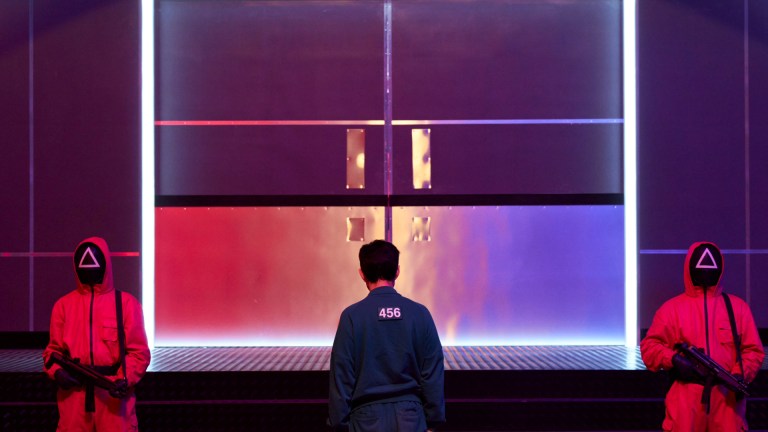 Lee Jung-jae as Seong Gi-hun approaches a guarded door in Squid Game S2