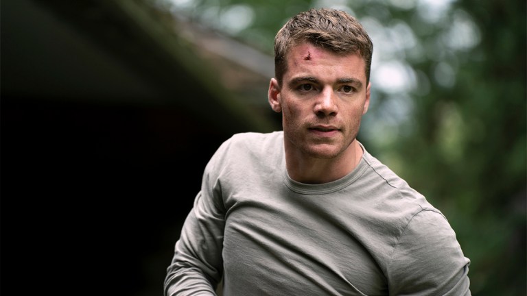 Gabriel Basso in a gray long-sleeved t-shirt in The Night Agent season one